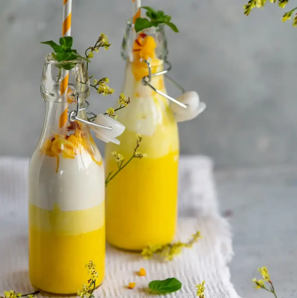 a glass of orange juice with a straw