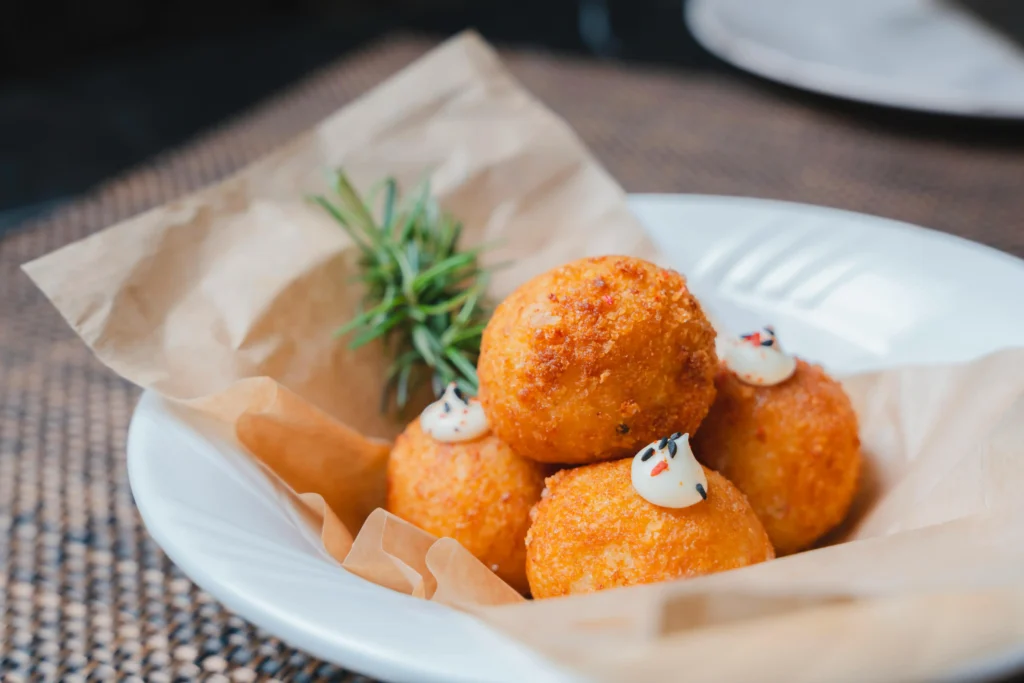 A plate of Wisconsin Cheese Curds with cheese and herbs on it