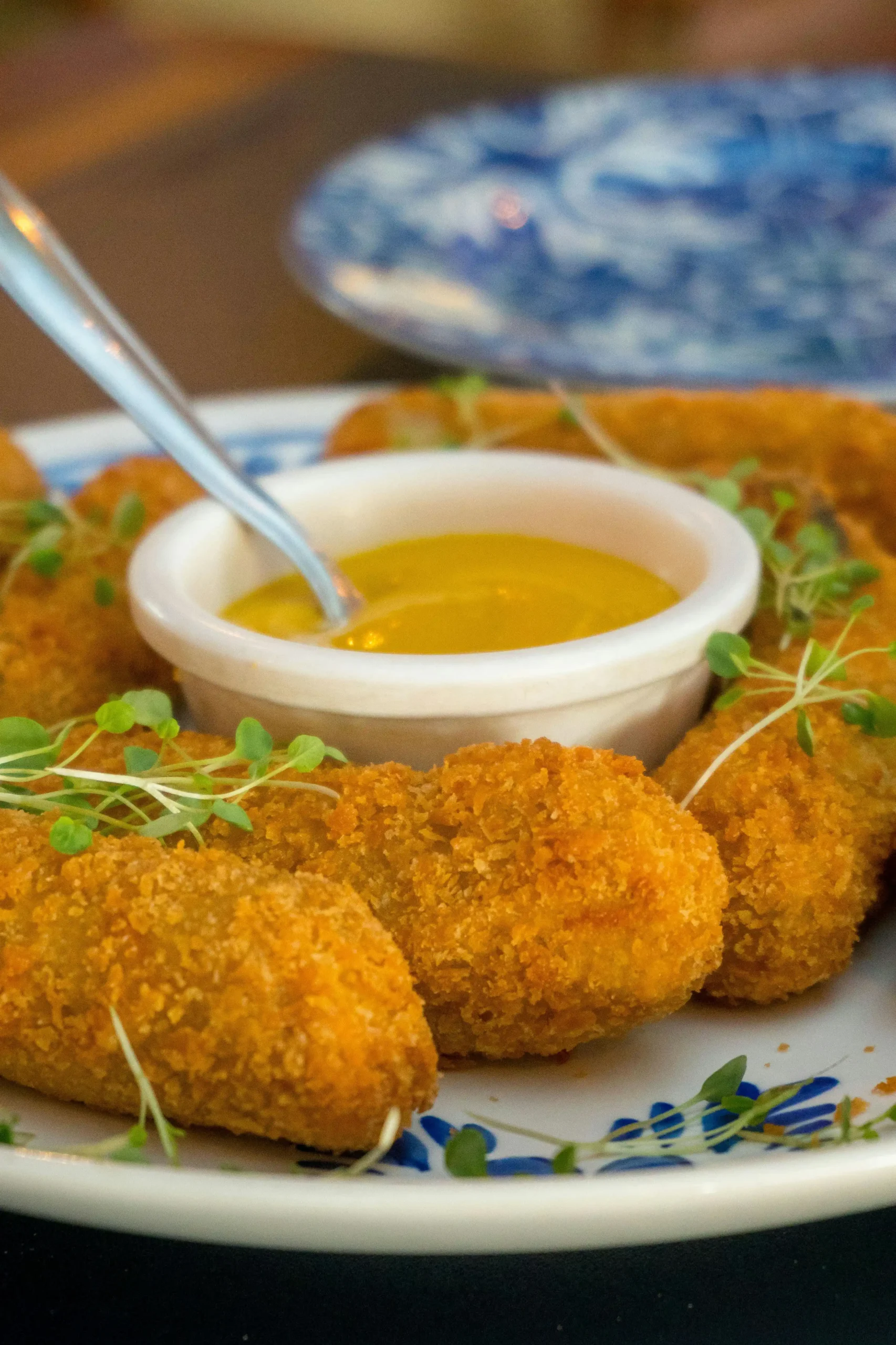 Hand holding a freshly fried Wisconsin cheese curd with gooey cheese